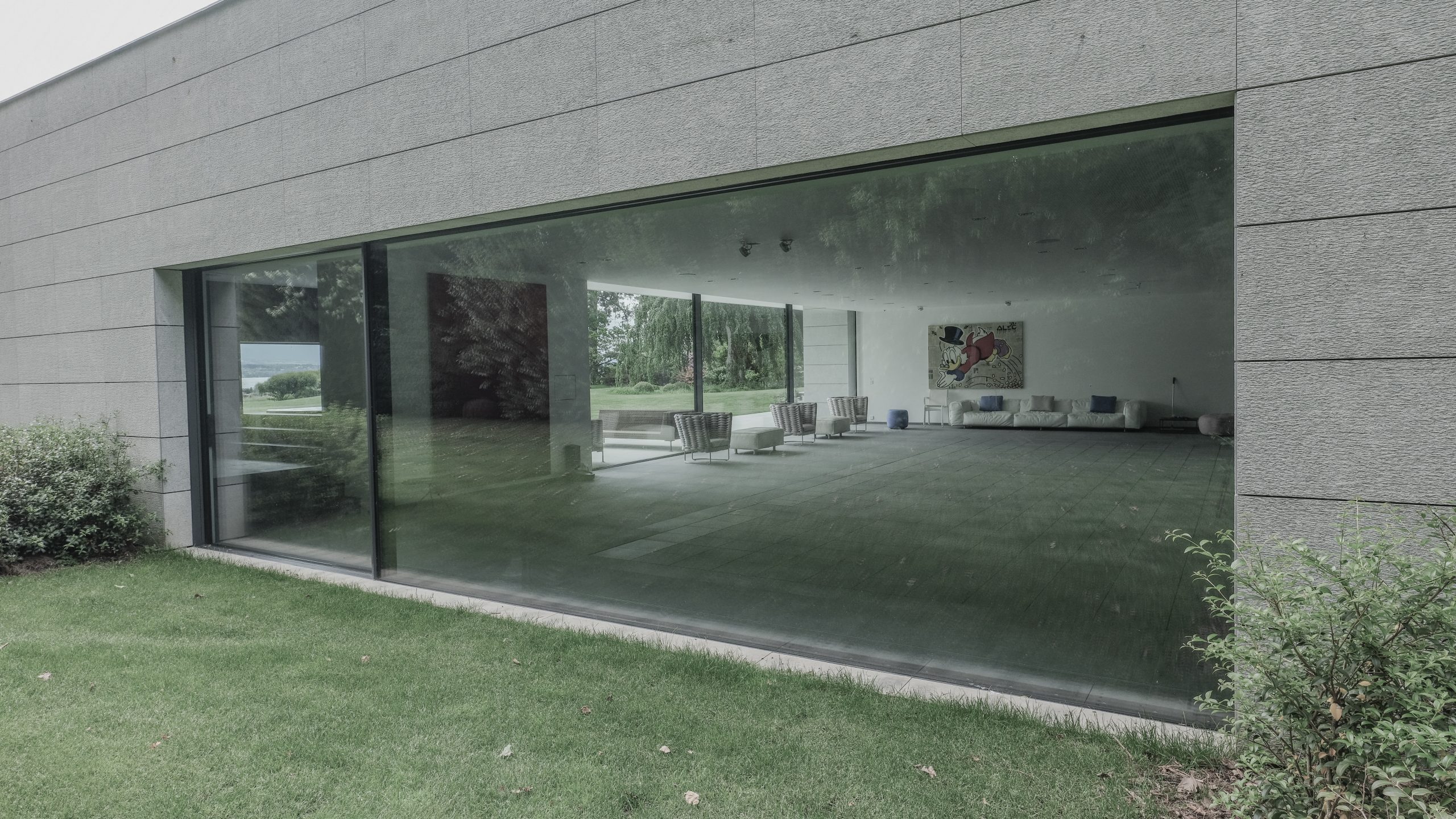 Fenêtre minimaliste aluminium à dormant caché intégrée dans une architecture contemporaine