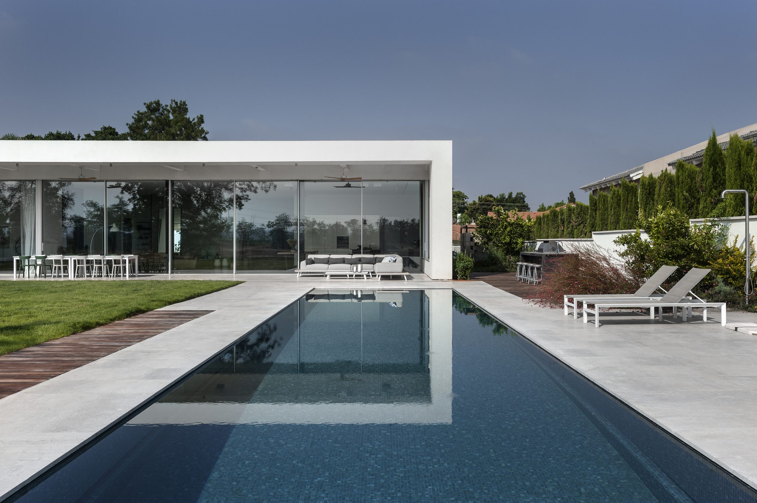 Grand coulissant minimaliste à seuil affleurant, vue depuis l'intérieur d'une villa d'architecte